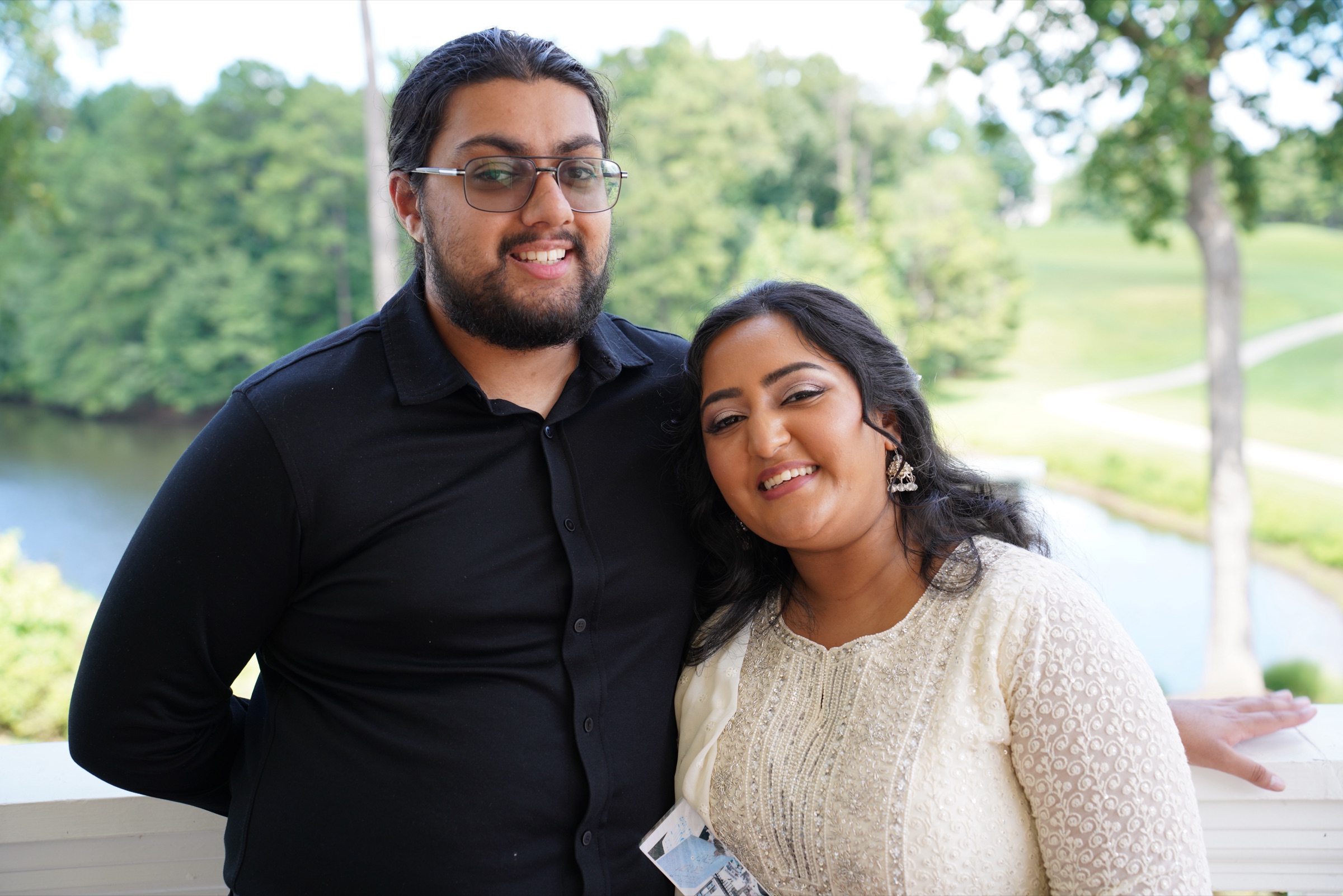 Young couple smiling on a balcony over a golf course